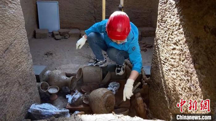 图为考古工作人员对古墓进行抢救性发掘清理(视频截图)。　重庆市文物考古研究院供图